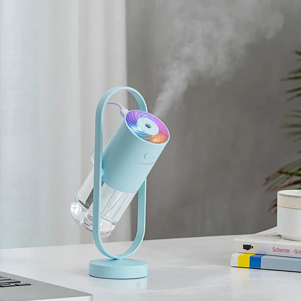 Pastel blue USB ultrasonic mini humidifier with projection night lights on a home office desk.
