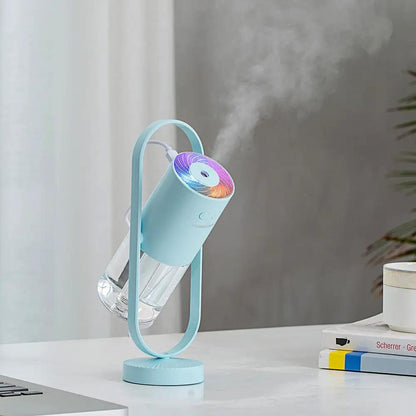 Pastel blue USB ultrasonic mini humidifier with projection night lights on a home office desk.