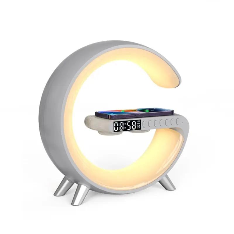 G-shaped LED lamp with Bluetooth speaker, wireless charger, app control; phone rests on curved arm with clock.