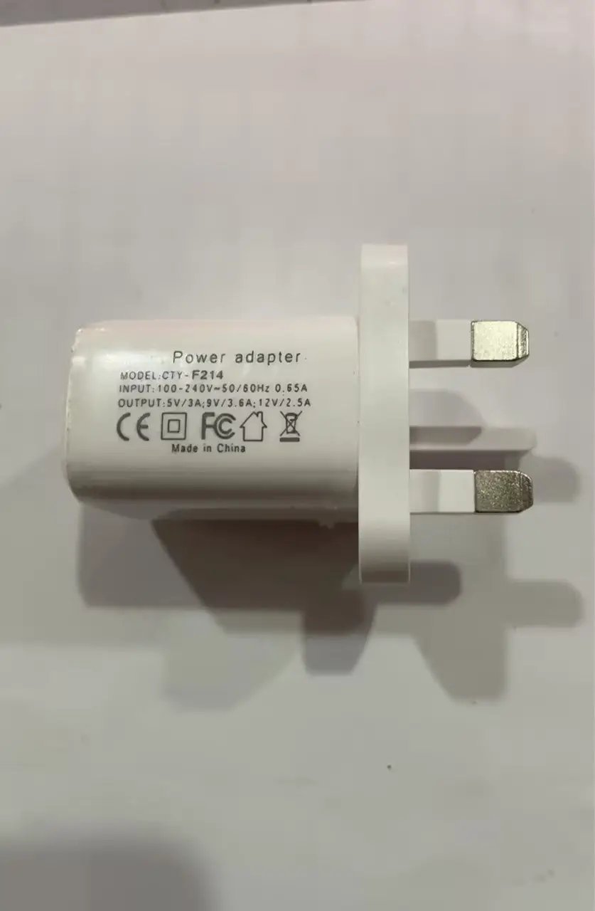 White CTY-F214 wall power adapter with two flat prongs and printed input/output specs.